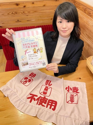 にしのみや市民祭りに出店する「みやれっこほーむ」の植村彩さん。のれんは会員の手作りだ＝西宮市内