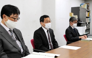 尼崎市議会議長に報告書を手渡した後、記者会見する市議会議員政治倫理審査会の丸山毅会長（中央）＝尼崎市東七松町１、尼崎市役所