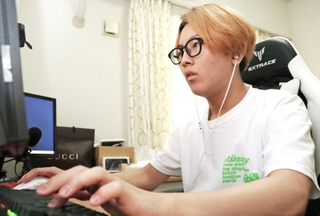 自宅でゲームをする能美利仁さん＝西宮市内