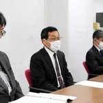 尼崎市議会議長に報告書を手渡した後、記者会見する市議会議員政治倫理審査会の丸山毅会長（中央）＝尼崎市東七松町１、尼崎市役所