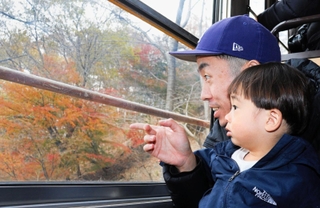 「紅葉きれいだね」と車窓からの眺めを楽しむ親子＝川西市黒川