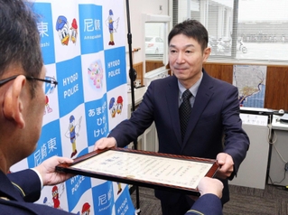 特殊詐欺を防ぎ感謝状を受け取る尼崎下坂部郵便局の局員岡田芳三さん＝尼崎市潮江５、尼崎東署