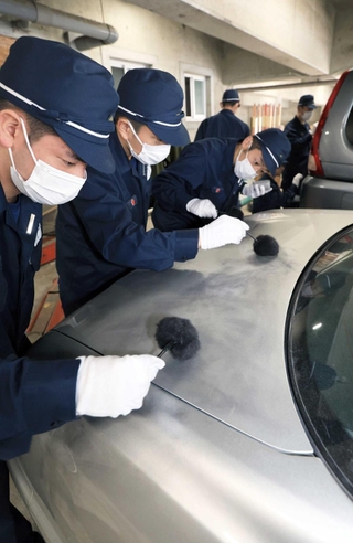 車に残された指紋を検出する鑑識作業に取り組む学生。「絶対あると思って作業しなければ見つからないぞ」。教官が注意を促す＝芦屋市朝日ケ丘町、兵庫県警察学校