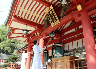 ササを使って拝殿のほこりを払う神職ら＝西宮神社
