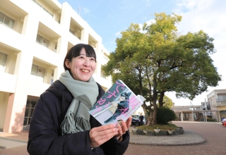 「坂本ですが？」の単行本を手に、作者佐野菜見さんとの思い出を語る同級生の小田木春菜さん＝西宮市学文殿町２、鳴尾高校（撮影・吉田敦史）