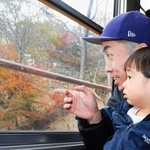 「紅葉きれいだね」と車窓からの眺めを楽しむ親子＝川西市黒川