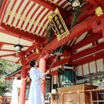 ササを使って拝殿のほこりを払う神職ら＝西宮神社