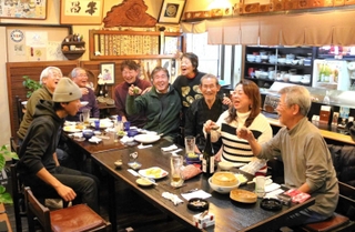 旧打出市場で和菓子店から転身した居酒屋「串昌」。店主の中路さん夫妻（右から３、４人目）の人柄に引かれ、常連客らが集う＝芦屋市打出町