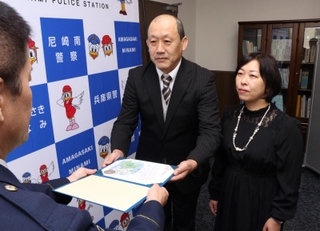 のじぎく賞を伝達される松永省三さん（中央）と妻の祐子さん（右）＝尼崎市昭和通２