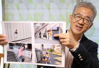 「善意のはやにえ」の写真を手に持つ吉永健一さん＝大阪府高槻市芥川町