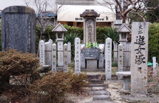 法然に念仏を授けられて、川に身を投げた５人の遊女を葬ったと伝わる遊女塚。花束や飲み物が供えられている＝尼崎市神崎町、梅ケ枝公園