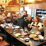 旧打出市場で和菓子店から転身した居酒屋「串昌」。店主の中路さん夫妻（右から３、４人目）の人柄に引かれ、常連客らが集う＝芦屋市打出町