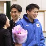 恩師の田中悠子さん（左）と大江誠さん（中央）に花束を渡してはにかむ岩渕緒久斗さん＝尼崎西高校