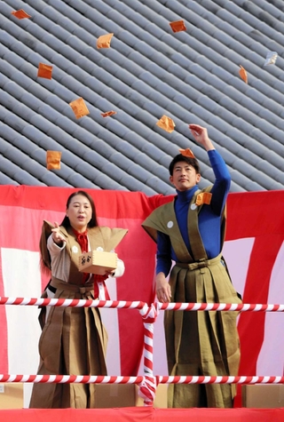 中山寺の星祭節分会で、勢いよく豆をまく能見篤史さん（右）と山崎晴恵市長＝宝塚市中山寺２