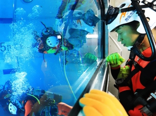 仲間の潜水活動をのぞき窓から見詰める＝西宮市津門大塚町、西宮消防署