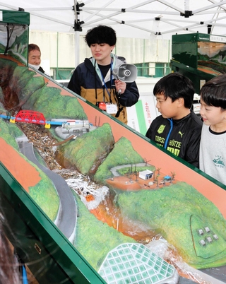 土石流を発生させ、治山ダムの有無で被害の違いを見ることができる模型＝猪名川町木津、楊津小学校