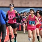 女子・尼崎市の１区志水麻紗選手（左）からたすきを受ける２区安田瑠捺選手＝加古川市の加古川河川敷マラソンコース（撮影・笠原次郎）