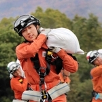 土のうを担いで走る岡村さん＝三木市志染町御坂