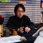 「怪談売買所」で客と話す怪談作家の宇津呂鹿太郎さん＝尼崎市杭瀬本町１、杭瀬中市場
