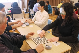 アイマスクを着けて囲碁を打つ参加者ら＝伊丹市昆陽池２