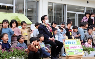 園庭で記念撮影する古田さんと園児ら＝伊丹市行基町１、中央保育所