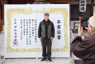 境内に設置された巨大な卒業証書で記念写真を撮る参拝者＝宝塚市伊孑志１