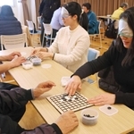 アイマスクを着けて囲碁を打つ参加者ら＝伊丹市昆陽池２