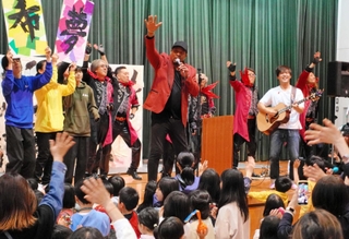 ラストは他の出演者らもステージに上り、スキップ・マーティンさん（中央）と一緒に歌った＝精道小学校