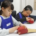 ミニランドセルを組み立てる子ども＝西宮市甲子園八番町、キッザニア甲子園