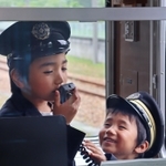 車掌になりきり、車内アナウンスに挑戦する子ども＝いずれも猪名川町松尾台１、日生中央駅