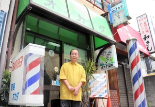 理容店の目の前にあった稲野市場に思いをはせる岡田高廣さん＝伊丹市稲野町３