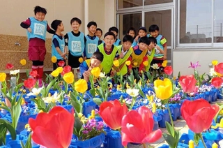 富山から届いた球根で育ったチューリップとスポーツクラブ２１安井の子どもたち＝西宮市安井町（ヤングネットワークとやま提供）