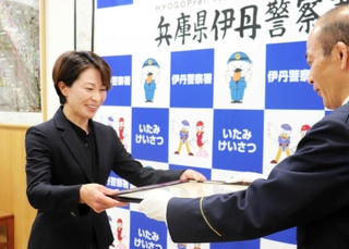 丸山文勝伊丹署長から感謝状を受け取る寺村みどりさん（左）＝伊丹市千僧１