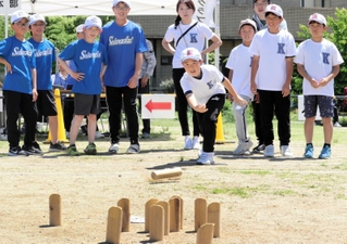 狙いを定め、真剣な表情で「モルック」を投げる子ども＝川西市火打１