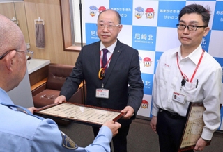 署長感謝状を受け取る尼崎西昆陽郵便局の林康弘局長（中央）と尼崎三反田郵便局の吉岡敦史局長代理（右）＝尼崎市南塚口町２、尼崎北署