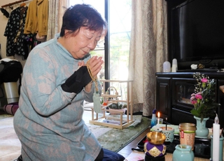 小瀬秋雄さんの遺影に手を合わせる母の盛山時枝さん＝伊丹市内