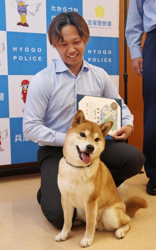 用水路に転落して動けなくなった高齢男性を救った柏田将輝さんとシバイヌの「てりたま」＝宝塚市旭町１、宝塚署