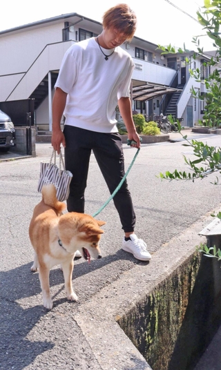 高齢男性が転落した用水路付近を散歩する柏田将輝さんと愛犬のてりたま＝宝塚市安倉南４