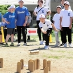 狙いを定め、真剣な表情で「モルック」を投げる子ども＝川西市火打１