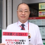 自作の注意喚起カードを提示しながら詐欺の可能性を説明した尼崎西昆陽郵便局の林康弘局長＝尼崎市西昆陽３