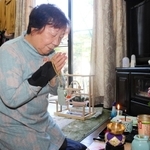 小瀬秋雄さんの遺影に手を合わせる母の盛山時枝さん＝伊丹市内