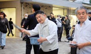 駅利用者に付近で客引き行為が禁止されたことを伝えるチラシなどを配る商店主ら＝西宮市甲子園口２