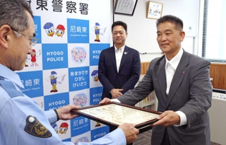 北尾祐一署長から署長感謝状を受け取る尼信けま支店の久代聖司さん（右）と、見守る清水良洋支店長（中央）＝尼崎東署
