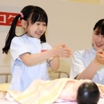 赤ちゃんをマッサージする前に手を温める子ども＝西宮市甲子園八番町、キッザニア甲子園