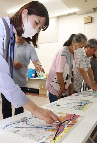 膨らみのある点で津波の浸水域などを表現した「さわるハザードマップ」に触れる市民ら＝西宮市六湛寺町