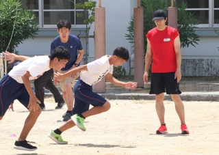 生徒たちの練習を見守る朝原宣治さん（右）ら＝尼崎市東七松町２、日新中学校