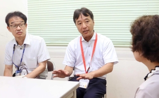 救助した女性の家族に当時の状況を話す野垣重文さん（左）と堀元学さん＝川西署