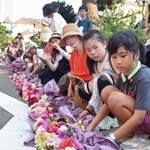 １列に花束を並べる参加者たち＝宝塚市栄町１、花のみち