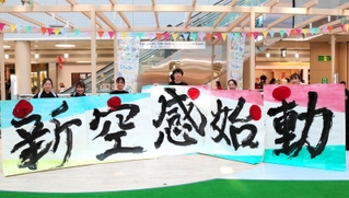 市制７０周年を祝い、改装されたアステ川西のぴぃぷぅ広場で書道パフォーマンスを披露したメンバーら＝８月８日、川西市栄町（提供）