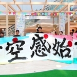 市制７０周年を祝い、改装されたアステ川西のぴぃぷぅ広場で書道パフォーマンスを披露したメンバーら＝８月８日、川西市栄町（提供）